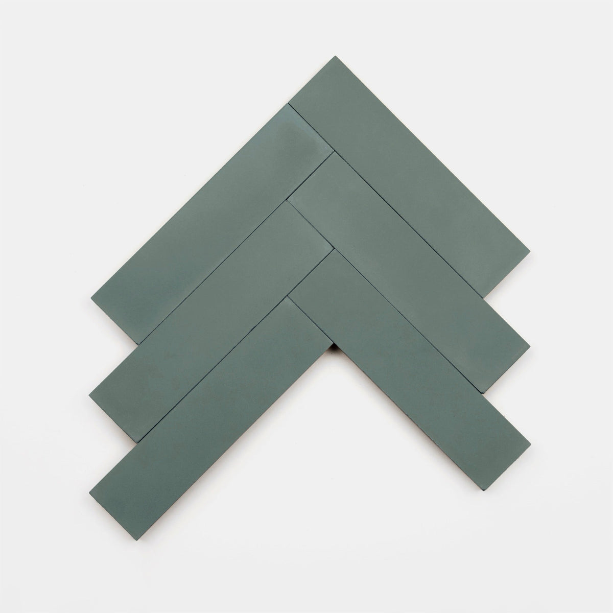 Five rectangular matte dark green Zeppelin 2x8 cement tile samples from vendor-unknown are arranged in a herringbone pattern on a plain white background, forming a geometric chevron or arrow-like upward shape.