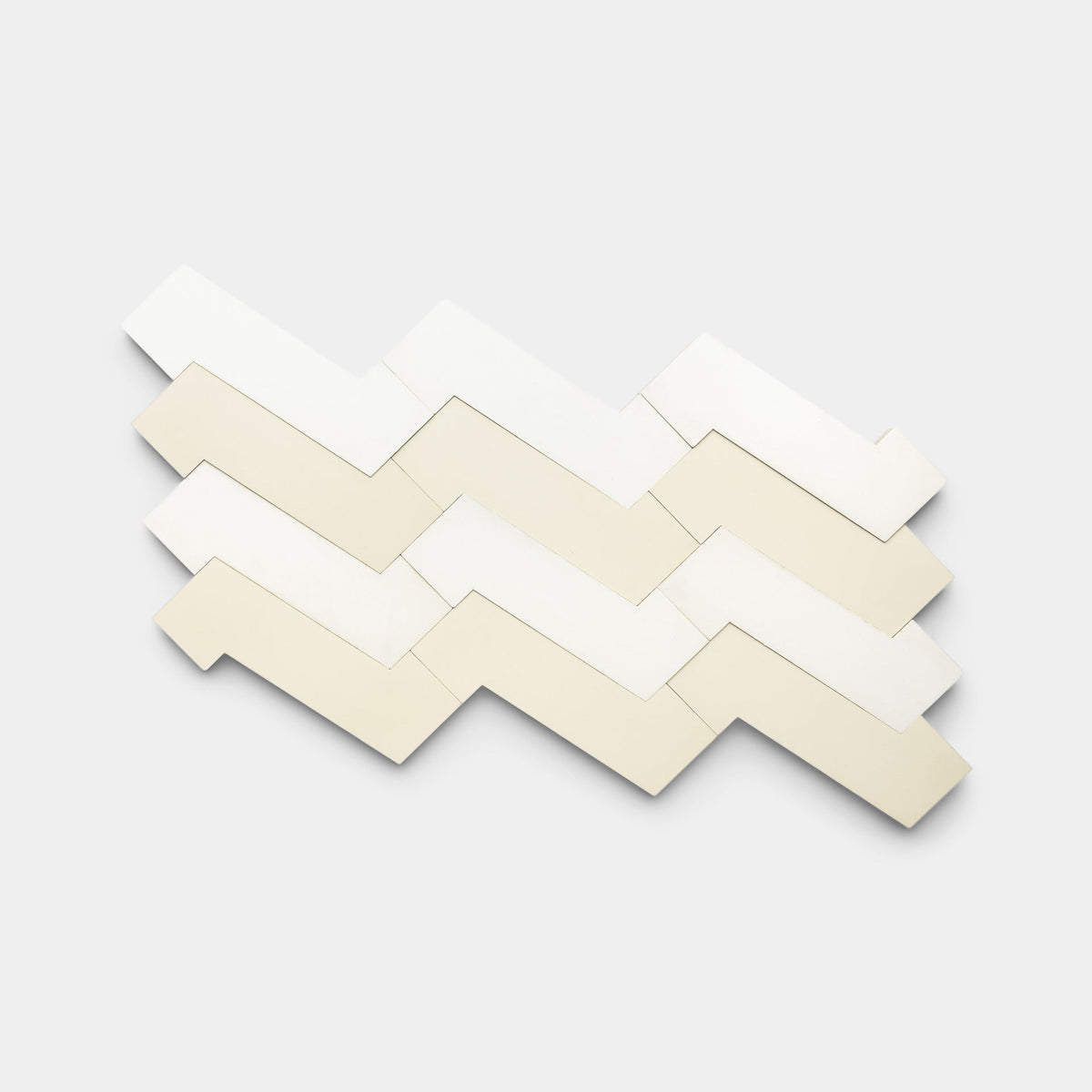 Four rows of Zia Tile's Zig Zag White + Bone handmade tiles are arranged in a staggered, horizontal pattern on a light gray background.