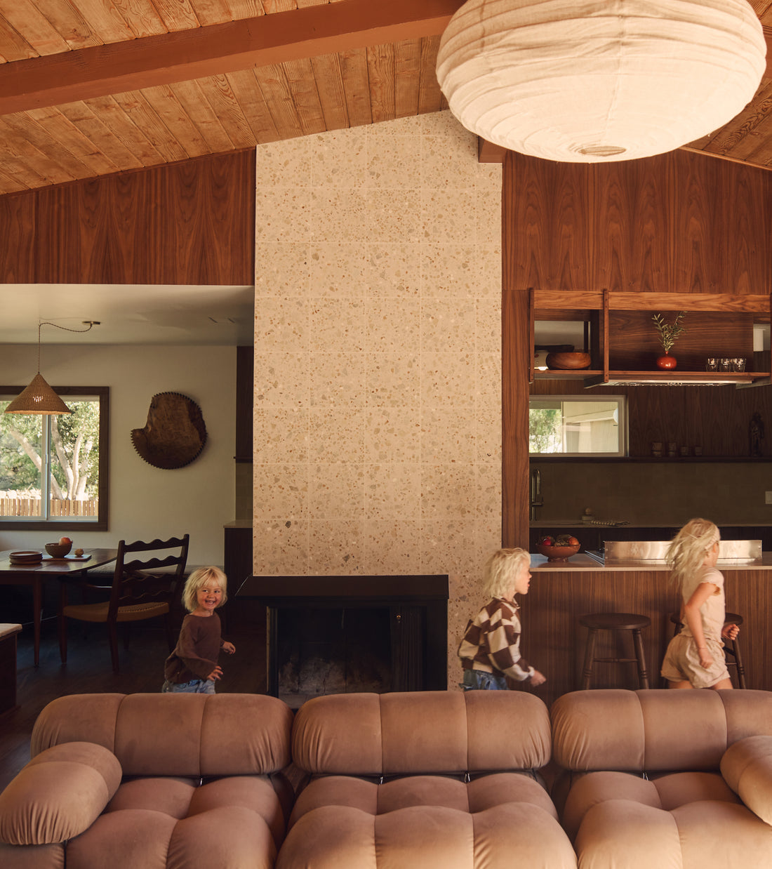 A group of children fill the living room with laughter, their playful energy bouncing off the elegant Apollo 12x12 cement tile flooring by Zia Tile.