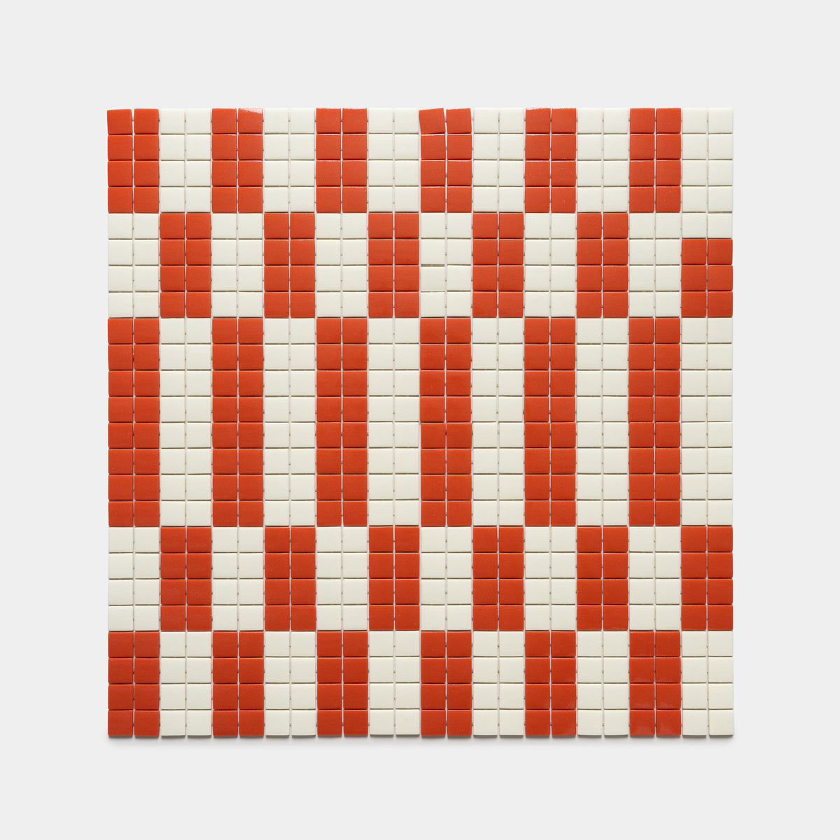The d'Orsay Roma + Milk tiles by Zia Tile form a symmetric geometric pattern with red columns and bands set against white tiles, creating a bold grid design.
