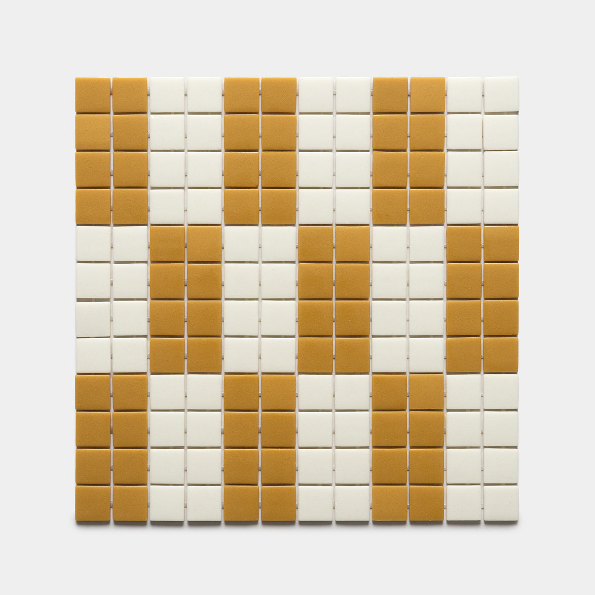 A geometric grid of small rectangular tiles in alternating rows of mustard yellow and off-white decorates the d'Orsay Rye + Milk, Sample by Zia Tile.