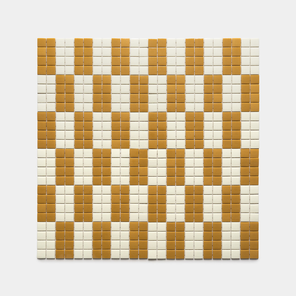 Zia Tile’s d'Orsay Rye + Milk features a grid of small square tiles in a repeating checkerboard pattern, with alternating vertical stripes of white and mustard yellow on a bright white background.