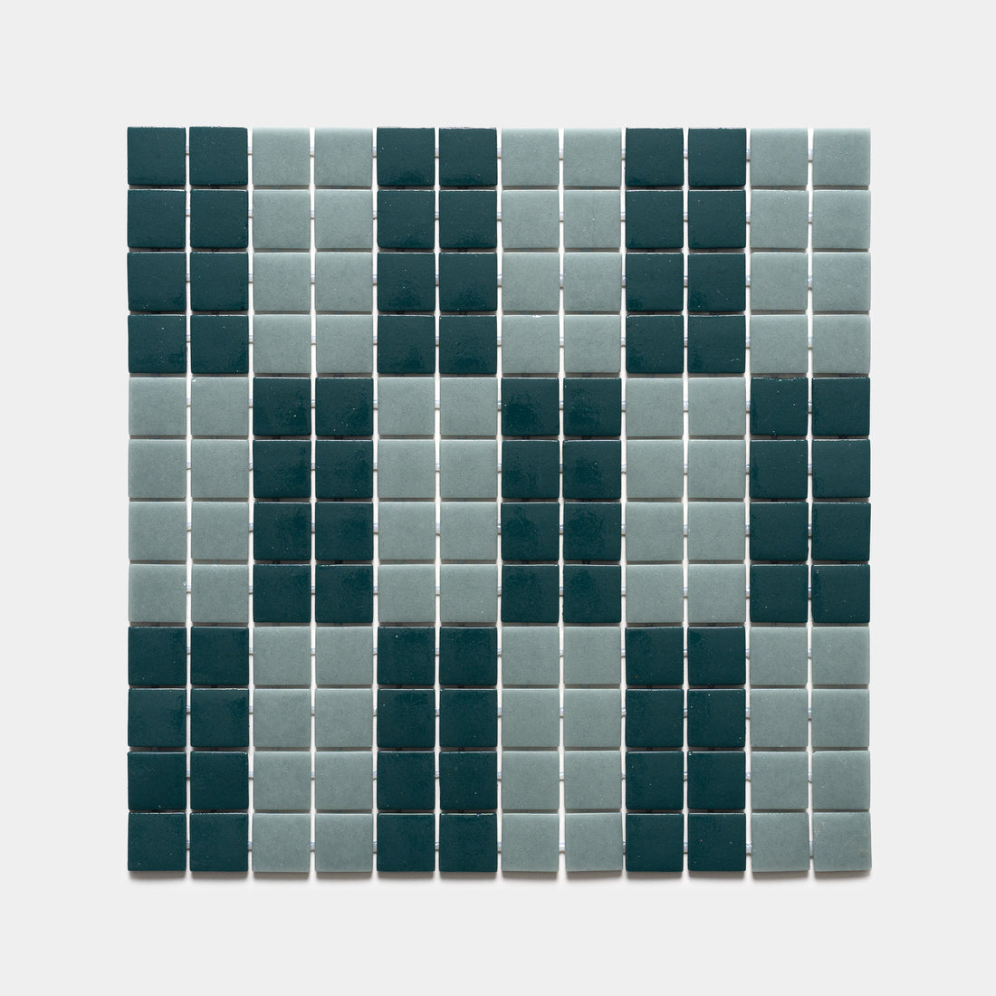 A grid of d'Orsay Vespertine + Marine Layer tiles by Zia Tile forms a geometric, face-like pattern in dark green and light grayish-blue on a light background.